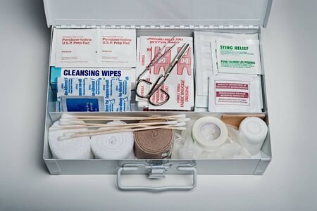 128872691-botiquín-de-primeros-auxilios-organizado-repleto-de-suministros-médicos-de-emergencia-sobre-fondo-gr
